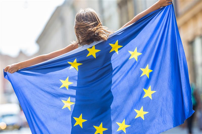 A girl from the back holding the European flag.